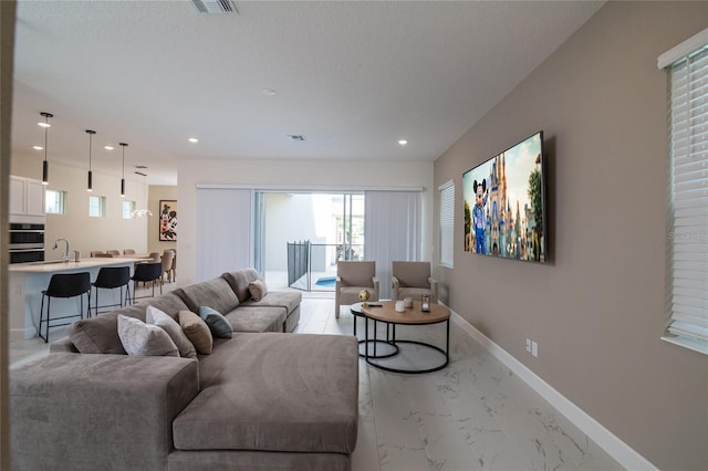 living room with light tile floors and sink