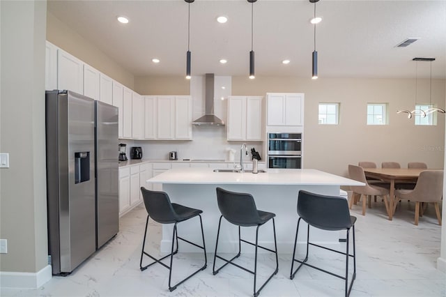 kitchen with light tile flooring, wall chimney range hood, sink, and stainless steel appliances