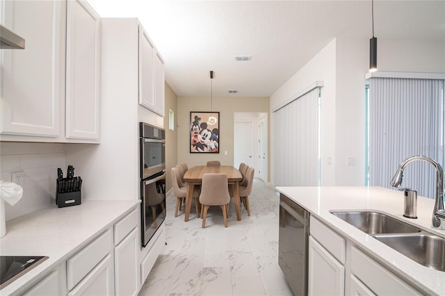 kitchen featuring white cabinets, backsplash, stainless steel appliances, light tile floors, and sink