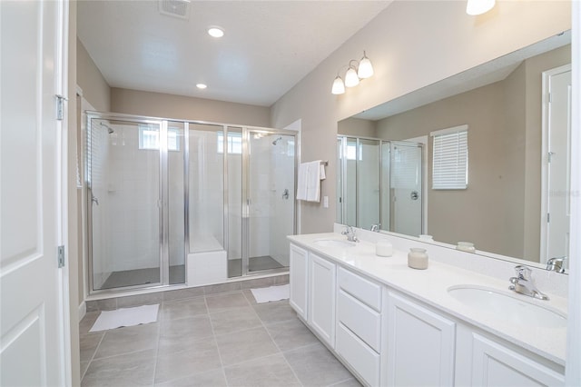 bathroom featuring walk in shower, double vanity, and tile flooring