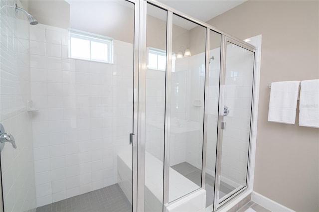 bathroom with a shower with shower door and tile flooring