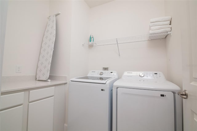 laundry room featuring cabinets and washer and dryer