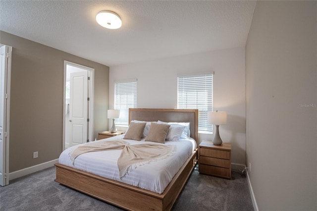 bedroom featuring a textured ceiling and dark carpet