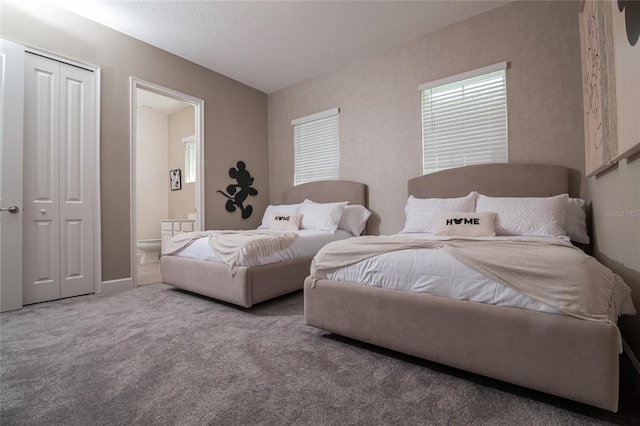 bedroom featuring a closet, carpet, and ensuite bath