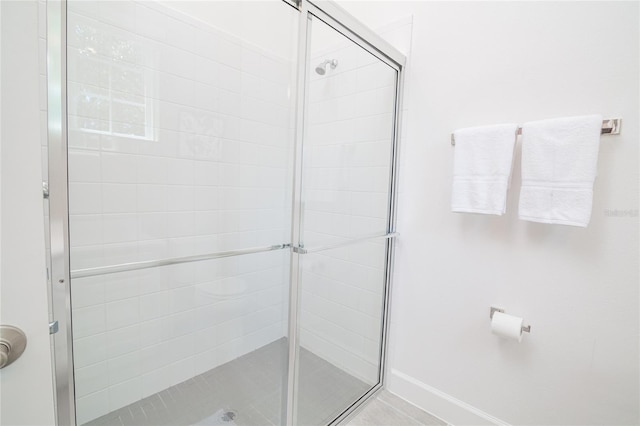 bathroom featuring a shower with door