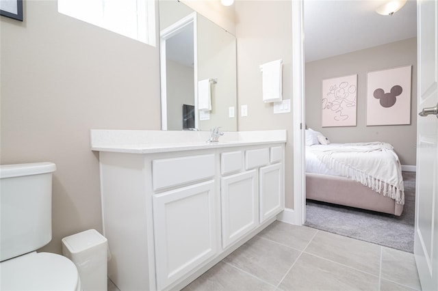 bathroom with toilet, tile flooring, and vanity