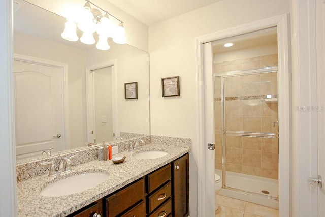 bathroom with toilet, tile patterned flooring, a shower with shower door, and vanity