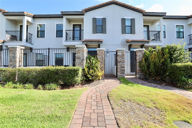 view of front of property with a front lawn and a balcony