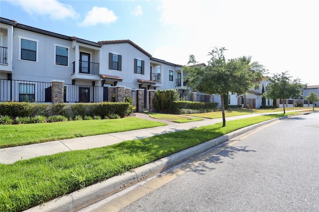 townhome / multi-family property with a front yard