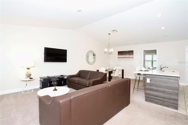 carpeted living room featuring an inviting chandelier, sink, and lofted ceiling