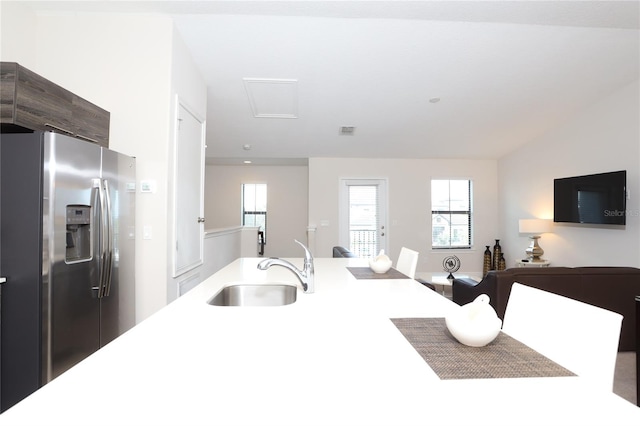 kitchen featuring stainless steel fridge with ice dispenser and sink