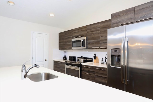 kitchen with dark brown cabinetry, sink, appliances with stainless steel finishes, and tasteful backsplash