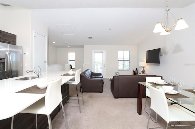 living room with vaulted ceiling, light carpet, and sink