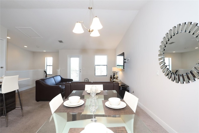 carpeted dining area featuring lofted ceiling and a chandelier