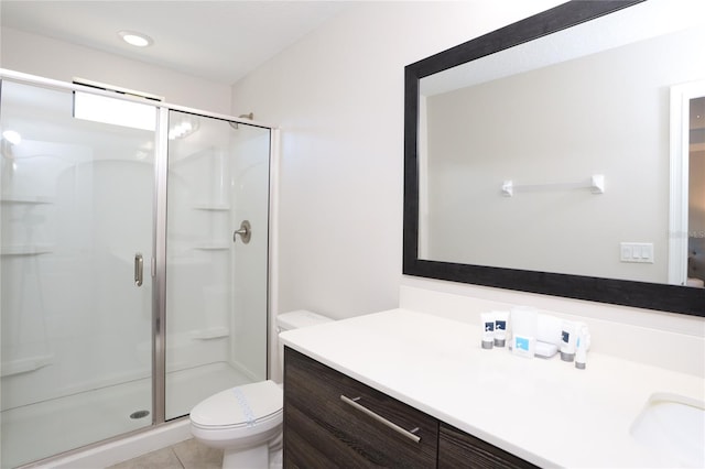 bathroom with tile floors, vanity, an enclosed shower, and toilet