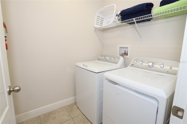 laundry area featuring washing machine and dryer, light tile flooring, and hookup for a washing machine