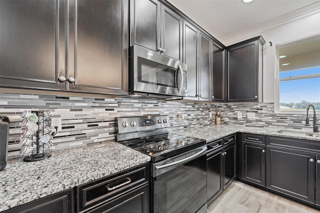 kitchen featuring stainless steel appliances, tasteful backsplash, sink, and light stone counters