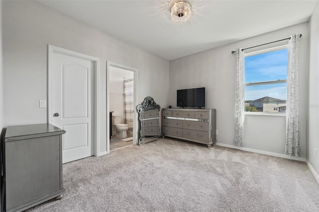 bedroom with ensuite bath and light carpet