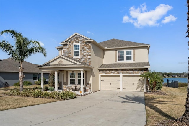 view of front of property featuring a water view, a porch, and a garage