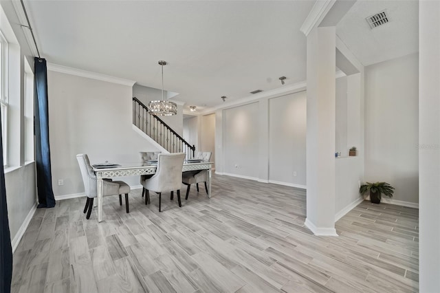 dining room with a notable chandelier, crown molding, and light wood-type flooring