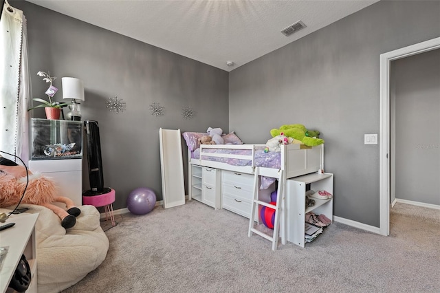 bedroom featuring light colored carpet and a textured ceiling