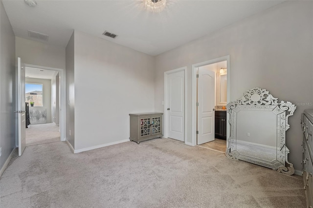 unfurnished bedroom with light colored carpet and ensuite bath