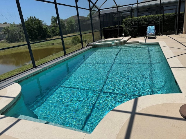 view of swimming pool featuring an in ground hot tub, a water view, glass enclosure, and a patio area