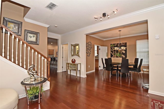 entrance foyer featuring crown molding, dark wood-type flooring, a notable chandelier, and a textured ceiling