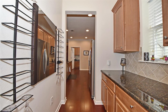 kitchen featuring dark hardwood / wood-style flooring, backsplash, ornamental molding, stainless steel fridge with ice dispenser, and stainless steel fridge