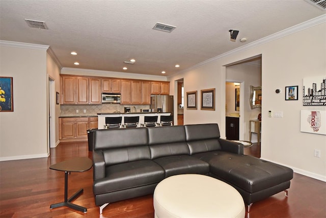 living room with a textured ceiling, dark wood-type flooring, and ornamental molding