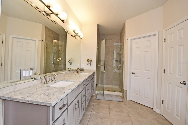 bathroom with tile flooring, oversized vanity, an enclosed shower, and double sink