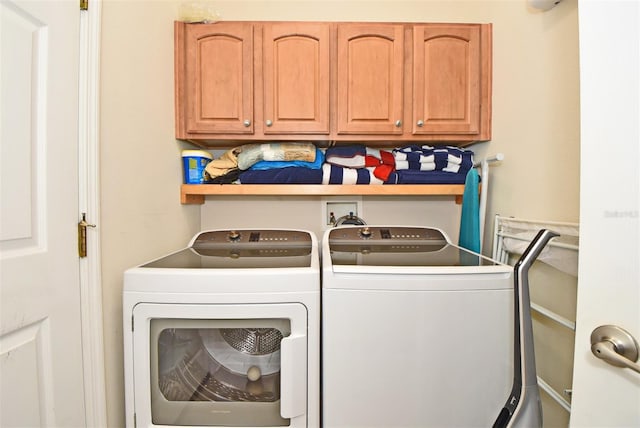 laundry room with washer hookup, washing machine and dryer, and cabinets