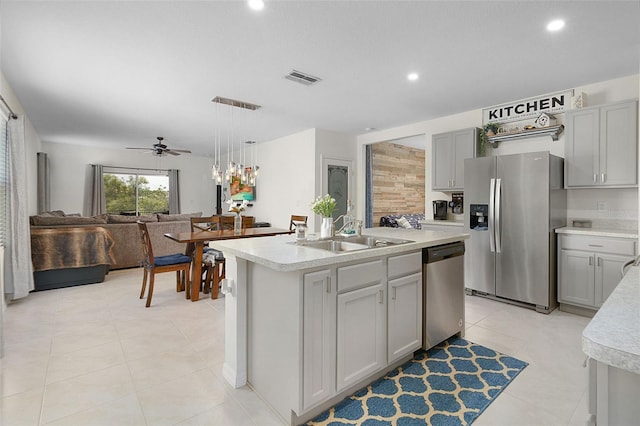 kitchen featuring stainless steel appliances, a center island with sink, ceiling fan, sink, and light tile floors