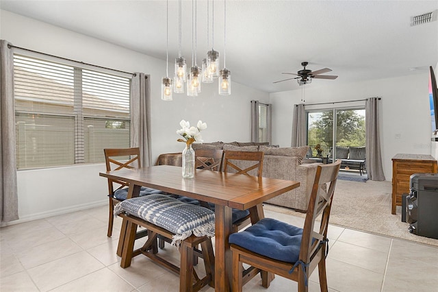 dining space featuring light tile floors and ceiling fan with notable chandelier