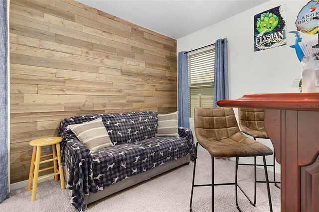 carpeted bedroom featuring wooden walls