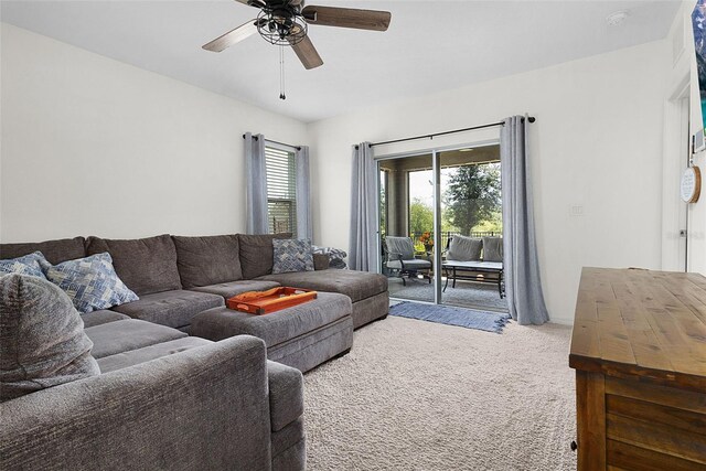 carpeted living room with ceiling fan