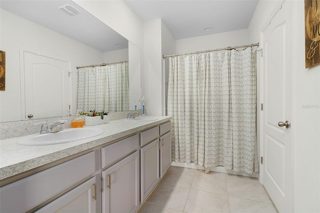 bathroom featuring vanity with extensive cabinet space, dual sinks, and tile flooring