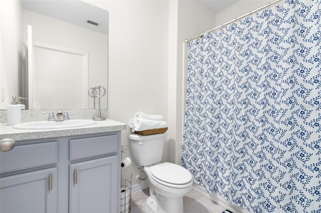 bathroom featuring toilet, tile floors, and large vanity