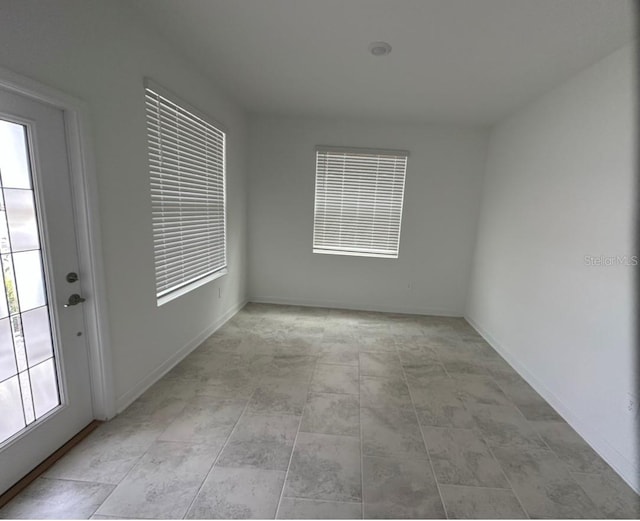 tiled empty room featuring a healthy amount of sunlight