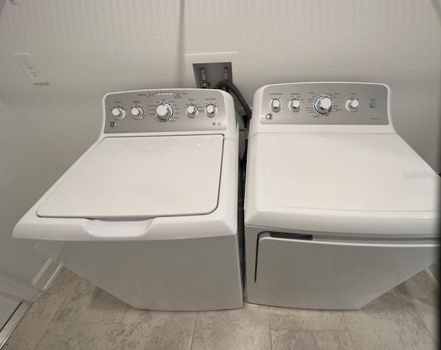 washroom with light tile floors, washer hookup, and washer and clothes dryer