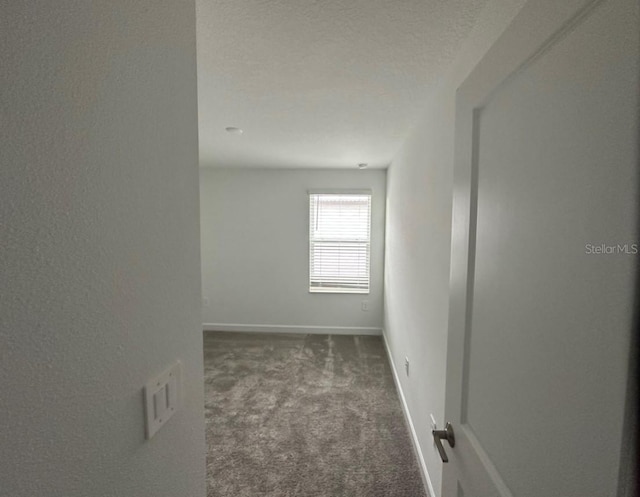 carpeted spare room with a textured ceiling