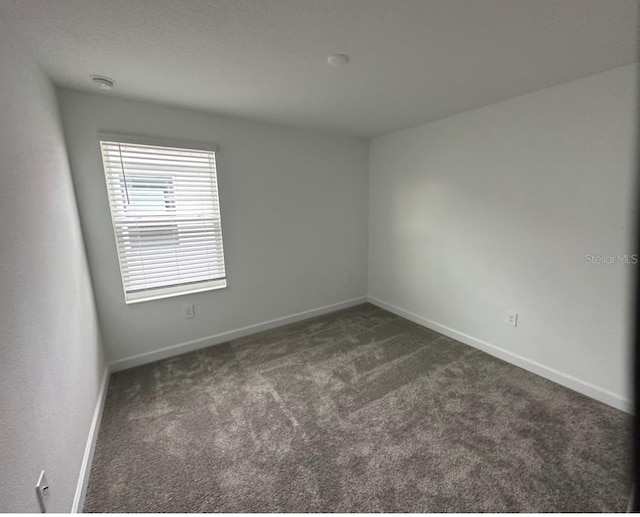 empty room with dark carpet