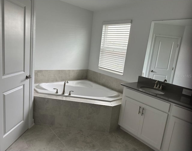 bathroom with tiled bath, vanity, and tile flooring