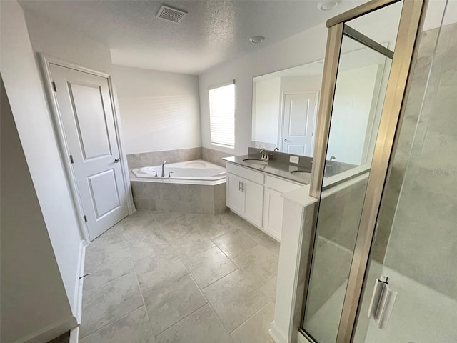 bathroom featuring shower with separate bathtub, tile flooring, vanity, and a textured ceiling