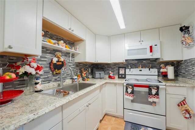 kitchen with white appliances, white cabinetry, sink, light tile patterned flooring, and tasteful backsplash