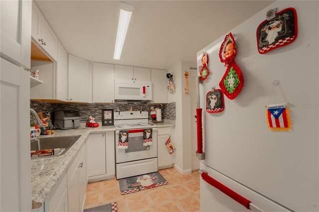 kitchen featuring white cabinetry, white appliances, backsplash, light tile patterned floors, and sink