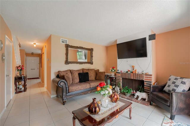 tiled living room with a brick fireplace and a textured ceiling