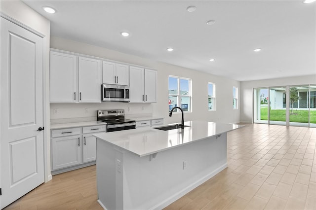 kitchen featuring white cabinets, appliances with stainless steel finishes, plenty of natural light, and sink