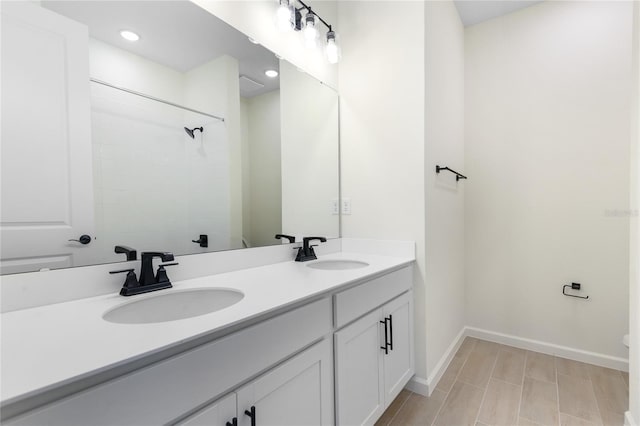 bathroom with a tile shower and vanity