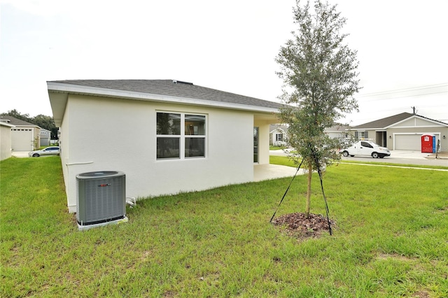 view of property exterior featuring a lawn, cooling unit, and a garage